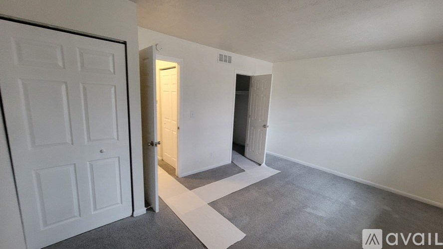 A room with a white door and a white wall with a window.