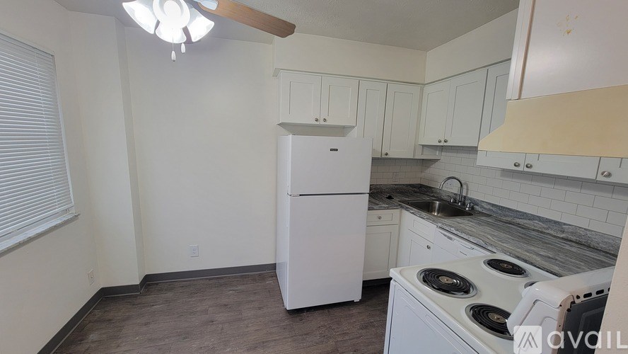 A kitchen with a white fridge and stove top oven.