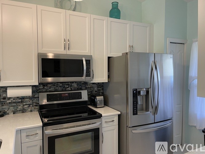 A kitchen with white cabinets and a black stove.