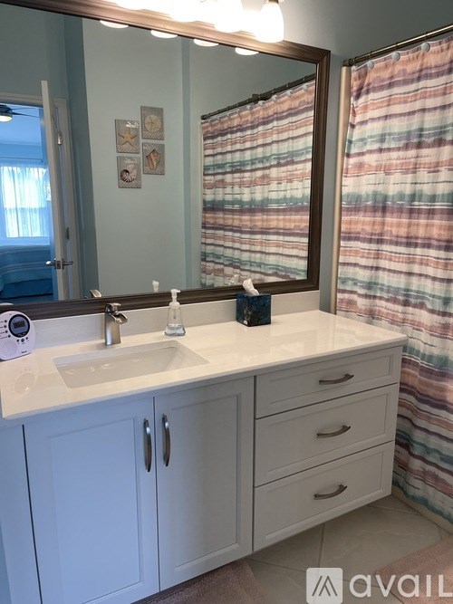 A bathroom with a sink, mirror, and cabinets.