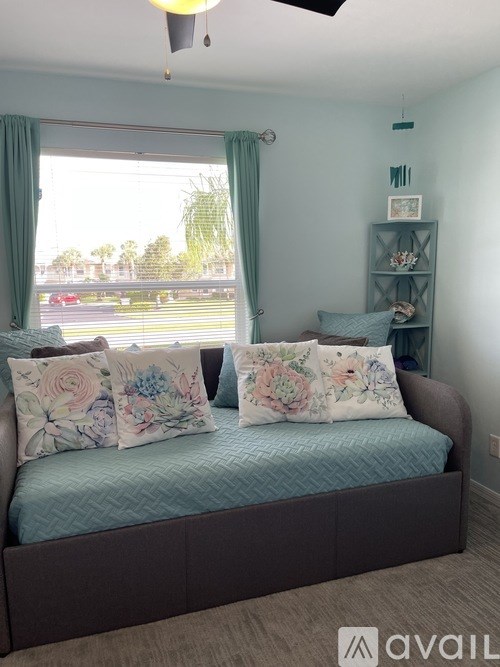 A bedroom with a bed and a window with curtains.