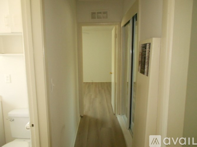 A hallway with a toilet visible on the left.
