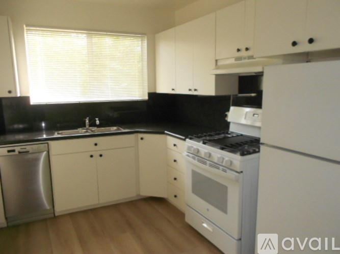 A kitchen with white cabinets and appliances.