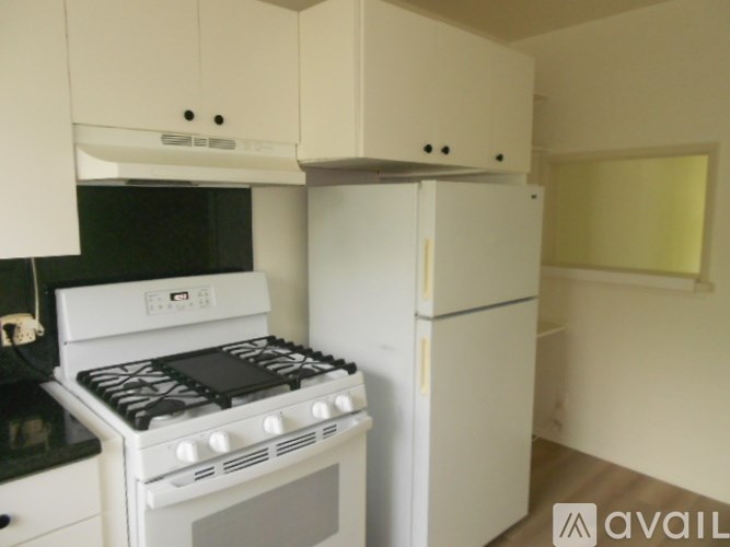 A white stove and refrigerator in a small kitchen.
