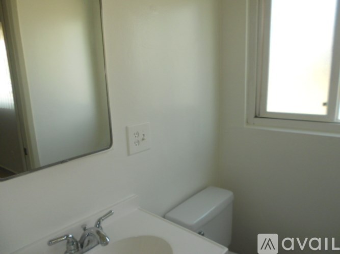 A bathroom with a sink, mirror, and toilet.