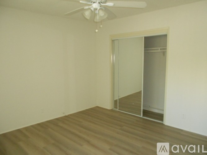A room with a ceiling fan and a sliding glass door.