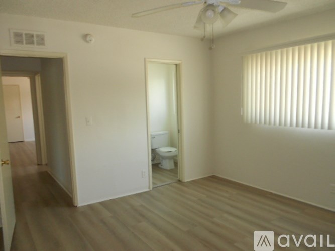A room with a toilet and a fan.
