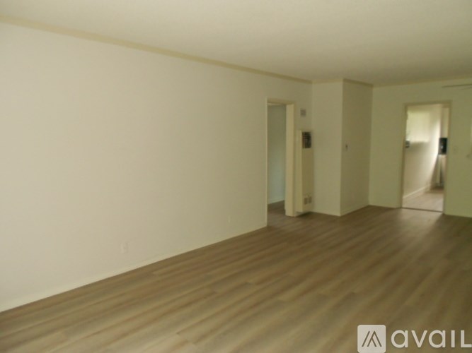 A room with wooden flooring and white walls.