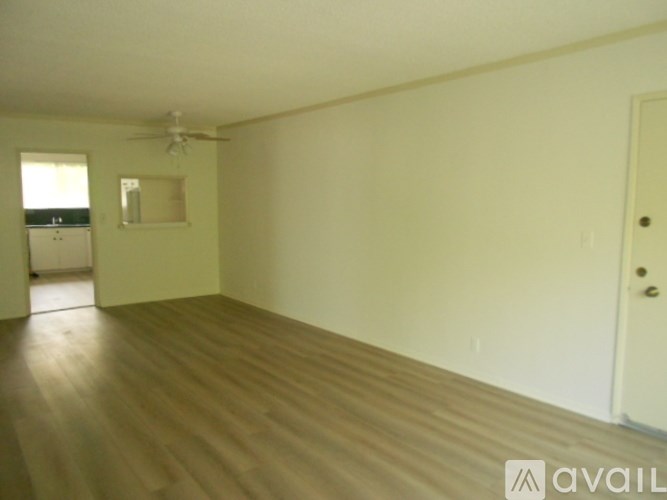 A room with wooden floors and a ceiling fan.