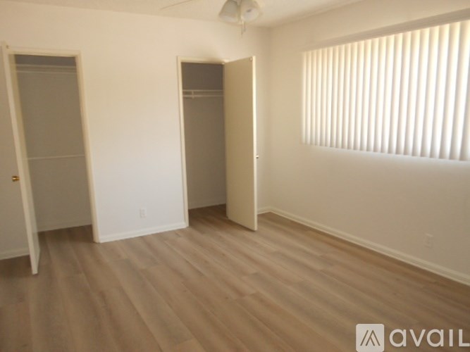 A room with wooden flooring and two closets.