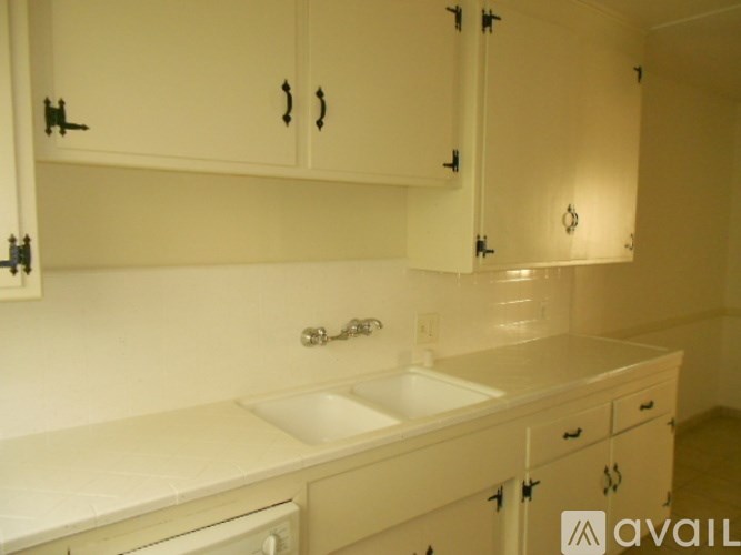 A white kitchen with a sink and a dishwasher.