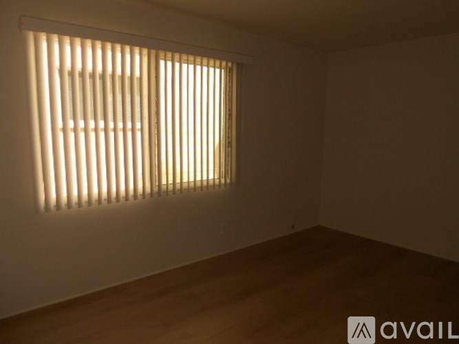 A room with a window covered by vertical blinds.