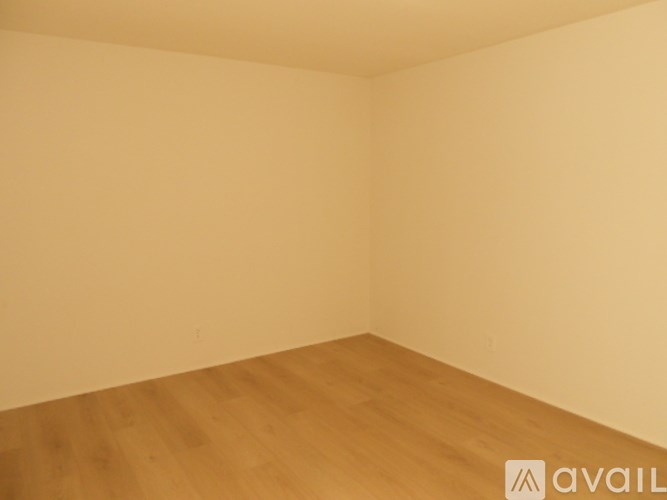 A room with wooden flooring and white walls.