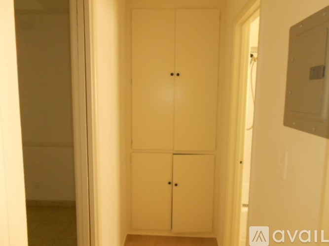 A white double door wardrobe with two black handles.