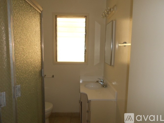 A small bathroom with a toilet, sink, and shower.