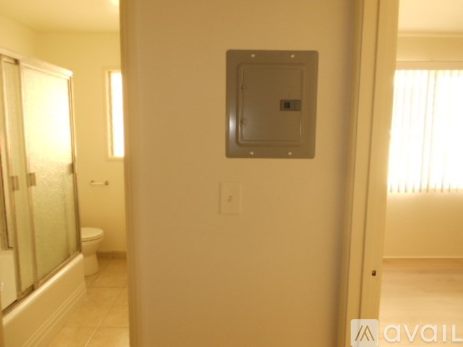 A bathroom with a toilet, sink, and a window.