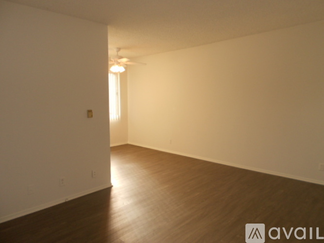 A room with wooden flooring and white walls.
