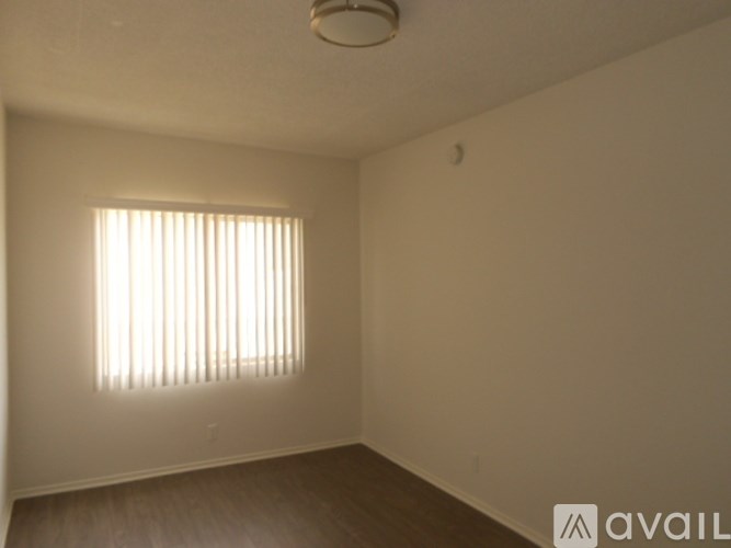A room with a window and wooden flooring.