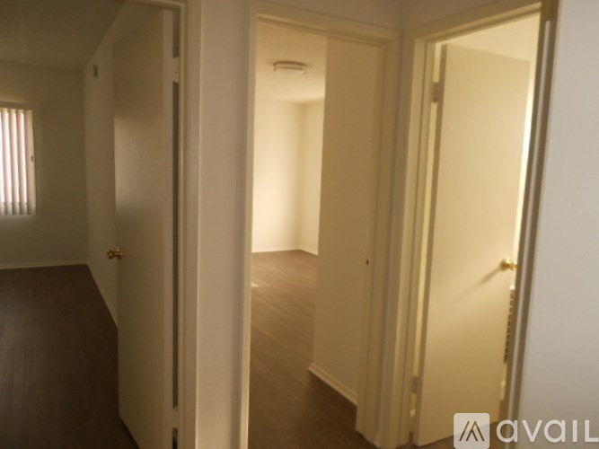 A hallway with two doors on either side and a window on the left.