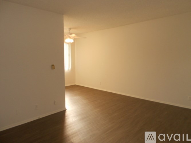 A room with wooden flooring and white walls.