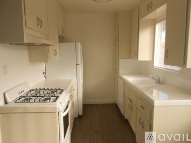 A small kitchen with a white stove and sink.