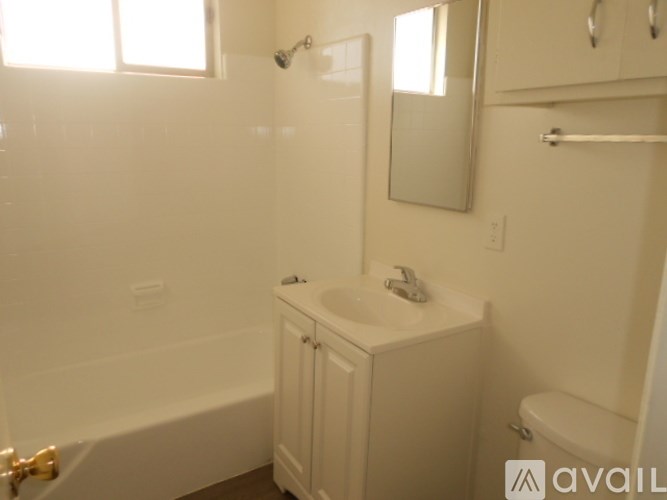 A white bathroom with a tub, sink, and toilet.