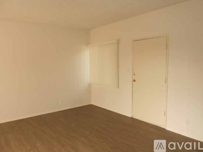 A room with a wooden floor and two doors.