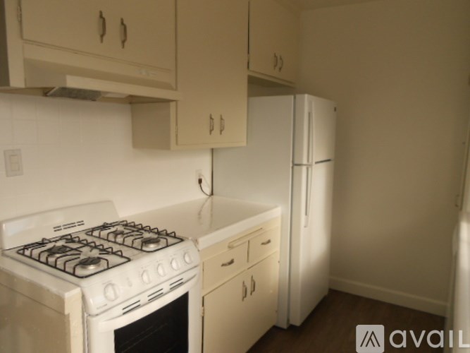 A white stove and oven in a kitchen with white cabinets.