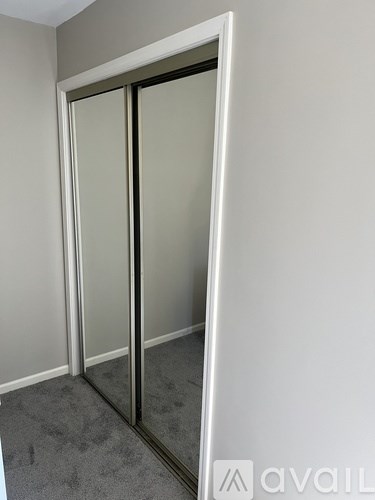A white door with a glass panel is in a room with grey carpet.