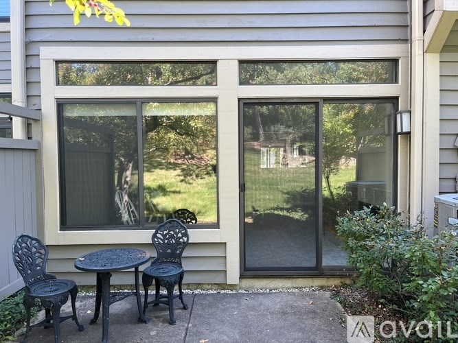 A patio with a table and chairs is set up outside a house.