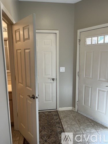 A hallway with two white doors and a tiled floor.