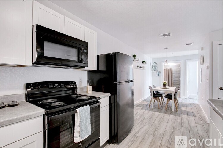A kitchen with black appliances and white cabinets.