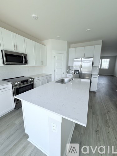 A kitchen with white cabinets and a large island.