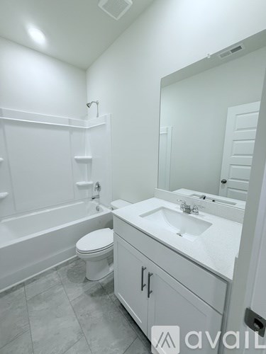A white bathroom with a toilet, sink, and bathtub.