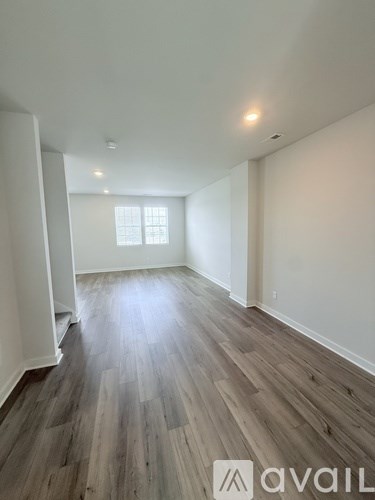 A room with wooden flooring and a window.