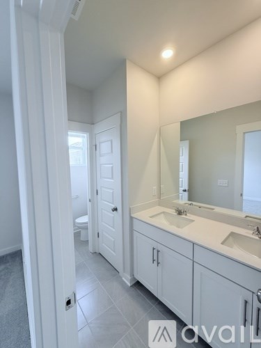 A bathroom with a white sink and a white toilet.