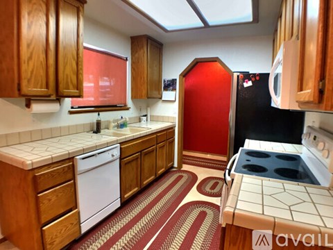 A kitchen with wooden cabinets and a red fridge.