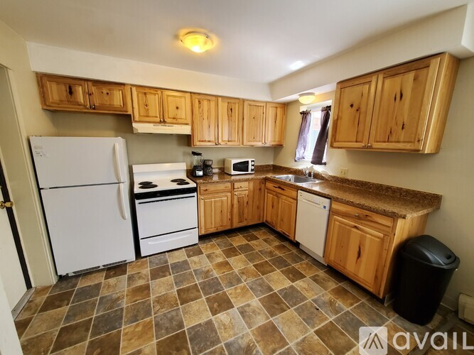 A kitchen with wooden cabinets and a tiled floor.