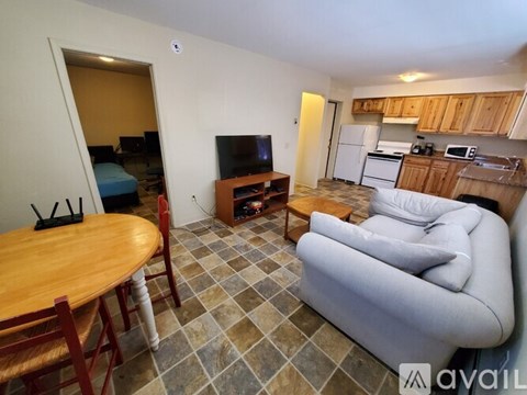 A living room with a grey couch, wooden table and a television.