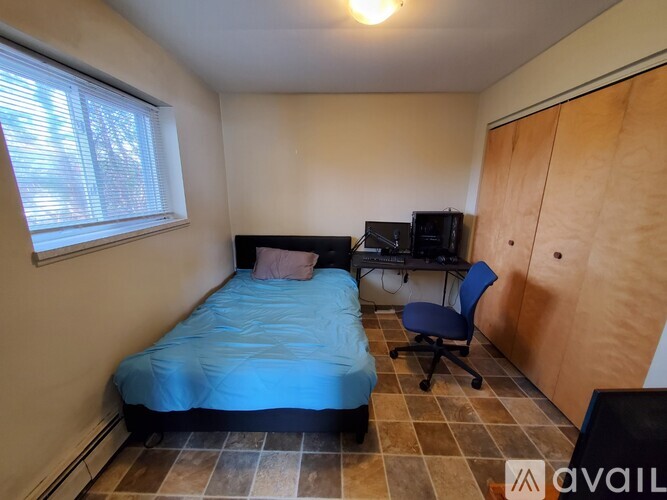 A bedroom with a bed, desk, and chair.