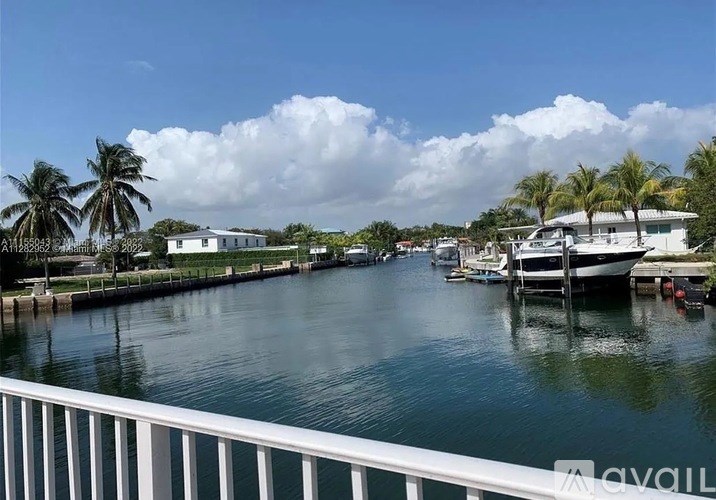 A view of a waterway with boats and houses on the side.