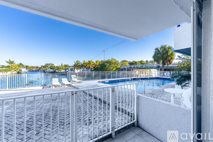 A spacious room with tiled flooring and a sliding glass door leading to a balcony.