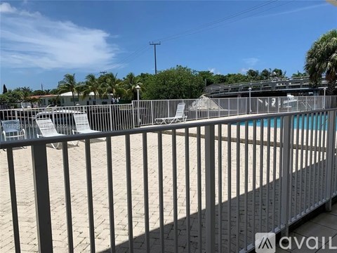 A pool area with a metal fence and steps leading to a pool.