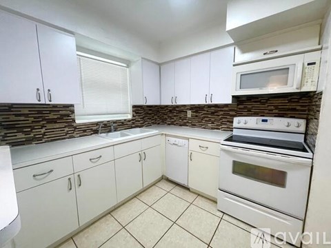 A kitchen with white appliances and a white tiled floor.