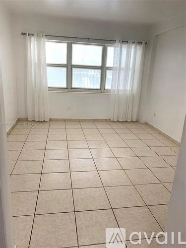 A room with a window and a tiled floor.