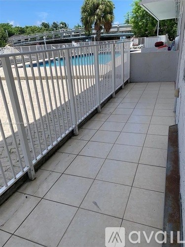 A patio with a pool in the background.