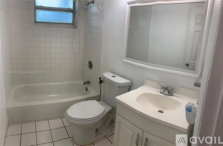 A white bathroom with a toilet, sink, and bathtub.