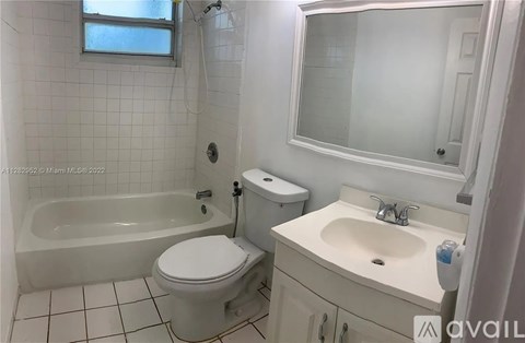 A white bathroom with a toilet, sink, and bathtub.