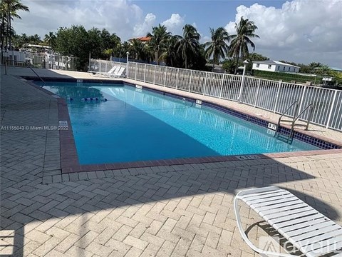 A pool with a red border and a white chair.