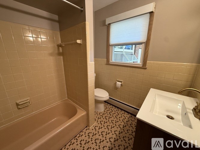 A bathroom with a beige tub, toilet, and sink.